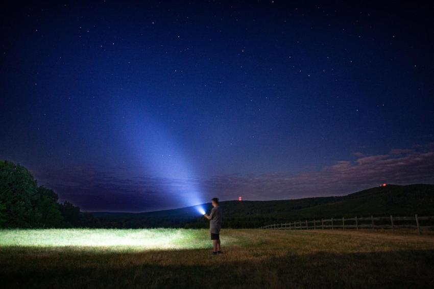 Person with flashlight under starry sky 2024 10 30 01 34 37 utc
