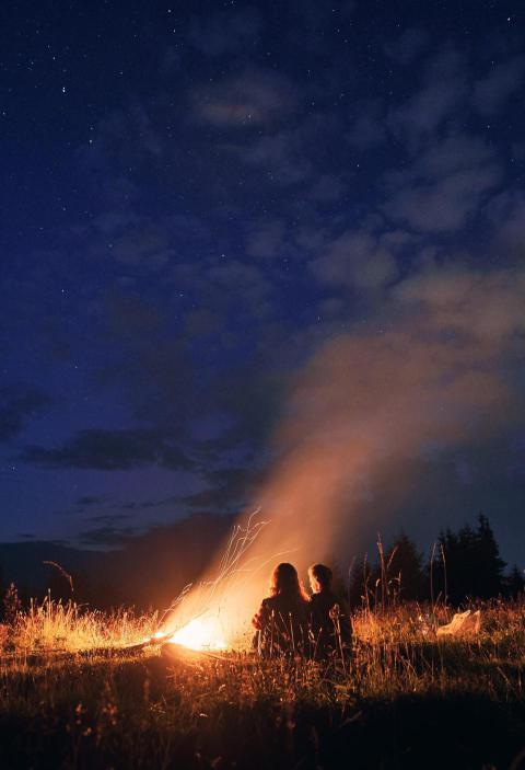 Young couple sitting near campfire under cloudy ni 2023 11 27 05 32 36 utc