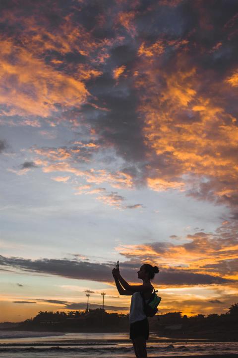 Woman taking photo of amazing colorful sunset with 2024 09 14 20 55 59 utc