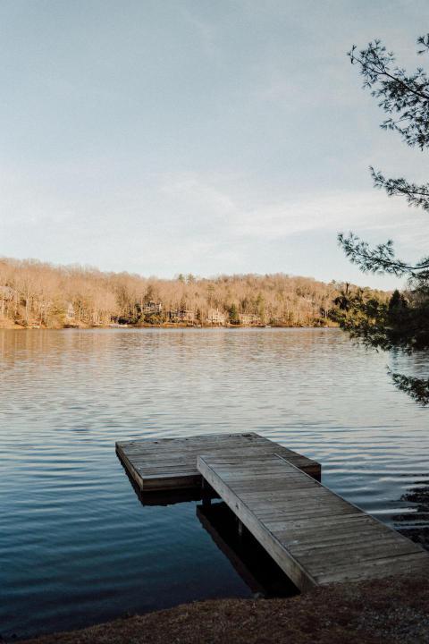 Serene lake with a wooden dock and a background of 2024 08 13 22 22 59 utc
