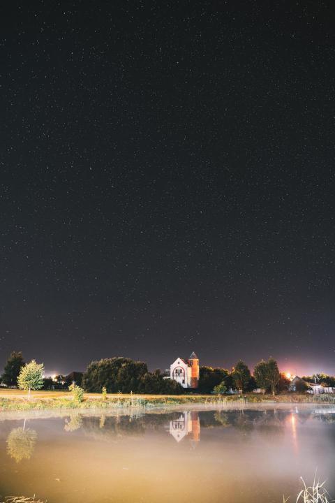 Night sky stars over river lake near houses in vil 2023 11 27 05 28 27 utc